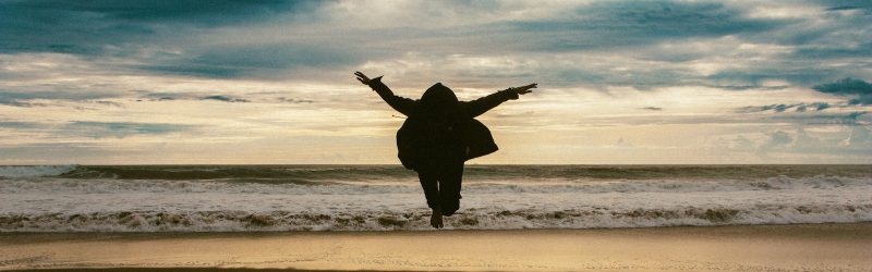 a person jumping in the air on a beach